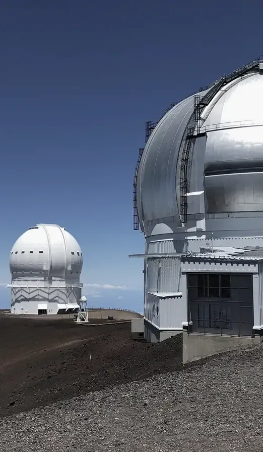 zdjęcie przedstawiające obserwatorium astronomiczne dwa budynki z teleskopami na szczycie góry